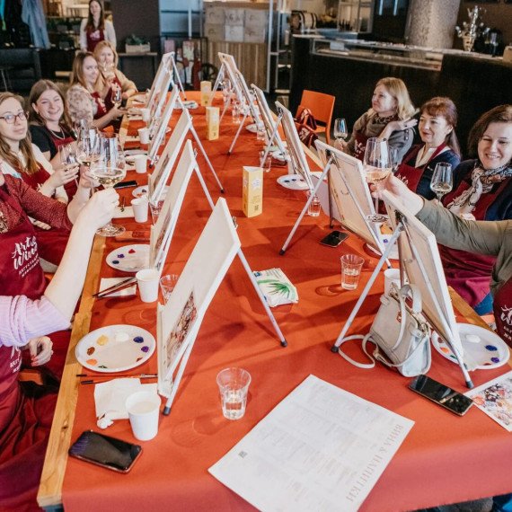 Группа людей на мастер-классе по живописи в ресторане с напитками и холстами Группа людей на мастер-классе по живописи в ресторане с напитками и холстами