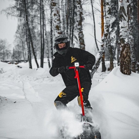 Мужчина катается на снегокате в зимнем лесу в России. Главное фото