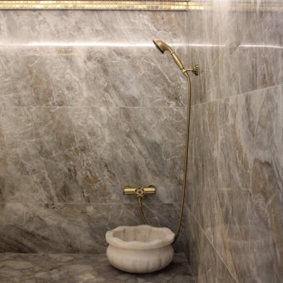 Душевая комната с мраморными стенами и ванной в современном интерьере