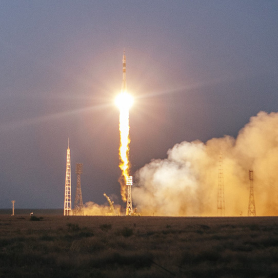 Запуск ракеты с космической площадки в темное время суток с ярким огнем и облаком дыма. Фото 50