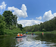 Каякеры сплавляются по спокойной реке в лесной местности в ясный летний день - превью 4 Каякеры сплавляются по спокойной реке в лесной местности в ясный летний день - превью 4