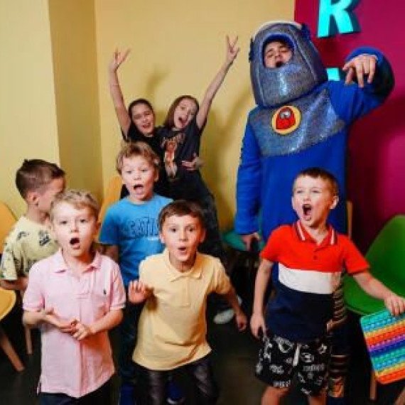 Дети празднуют день рождения с аниматором в костюме в развлекательном центре Дети празднуют день рождения с аниматором в костюме в развлекательном центре