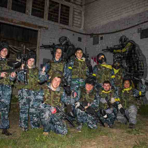 Группа людей в камуфляжной форме позирует с пейнтбольным оборудованием на фоне граффити. Фото 8