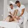 Массаж с двумя массажистами в спа-салоне, расслабляющая атмосфера и ухоженный интерьер на фоне - превью 1