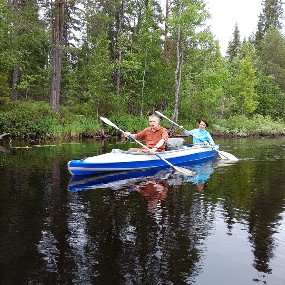 Каякеры наслаждаются спокойствием лесного озера в летний день Каякеры наслаждаются спокойствием лесного озера в летний день