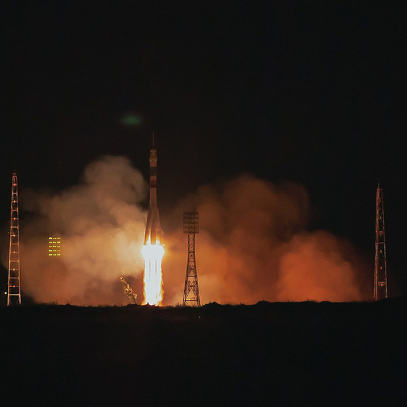 Запуск ракеты в ночном небе над космодромом, освещающим окрестности ярким пламенем. Фото 15