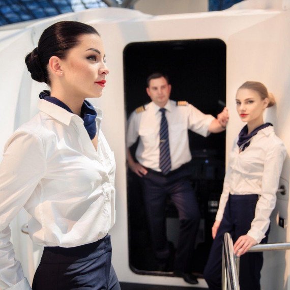 Стюардессы и пилоты на борту самолета в аэропорту Стюардессы и пилоты на борту самолета в аэропорту
