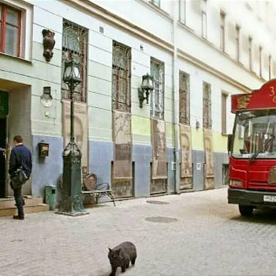 Улица с автобусом 302, скульптурами и черным котом в городе. Фото 9