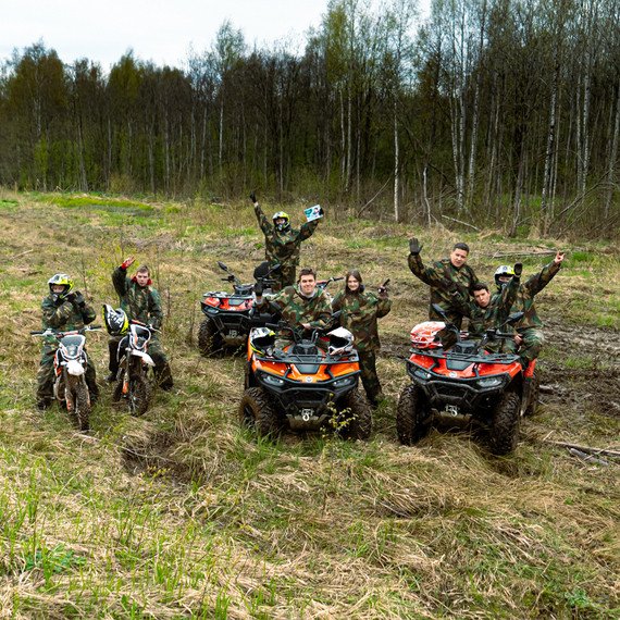 Группа людей на квадроциклах в лесу празднует успех на соревнованиях в травяной местности весной