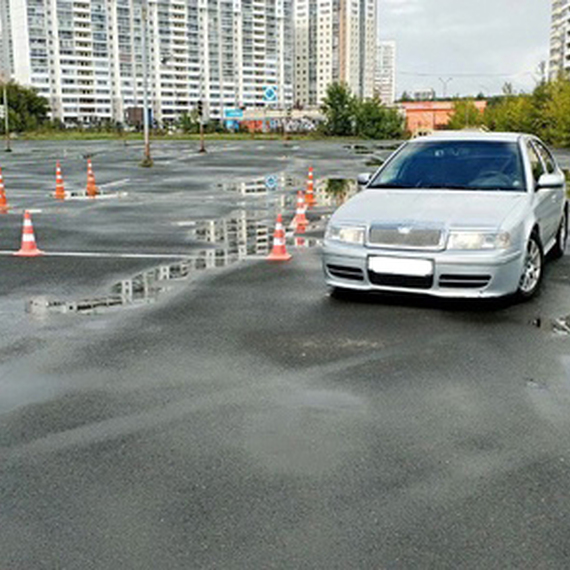 Автомобиль на площадке для учебной вождения после дождя в жилом районе. Фото 7