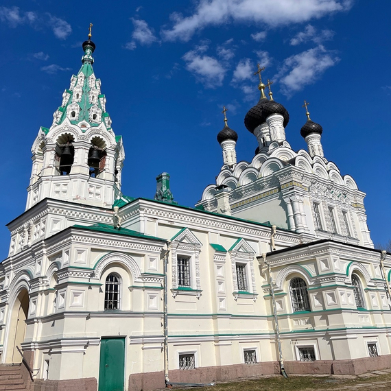 Красивая церковь с зелеными крышами на фоне голубого неба, расположенная в живописном месте. Фото 4