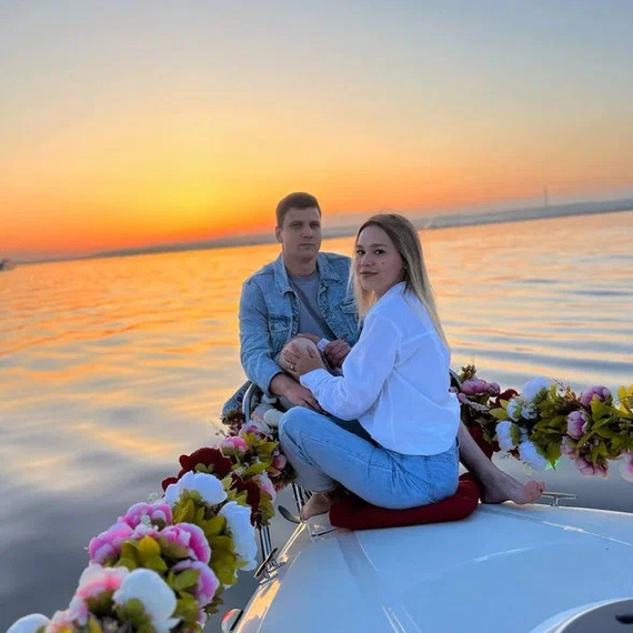 Молодая пара на лодке с цветами во время заката над спокойной водой. Фото 9