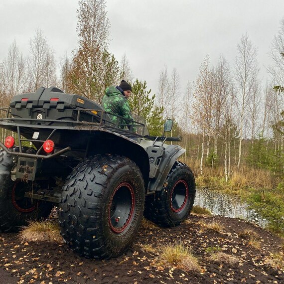 Квадроцикл на лесной тропинке рядом с водоемом в осенний день