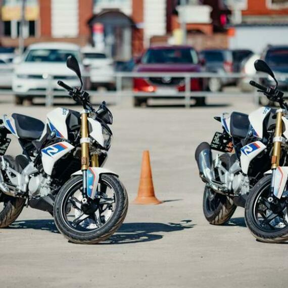 Два спортивных мотоцикла на парковке рядом с автомобилями в солнечный день. Фото 9
