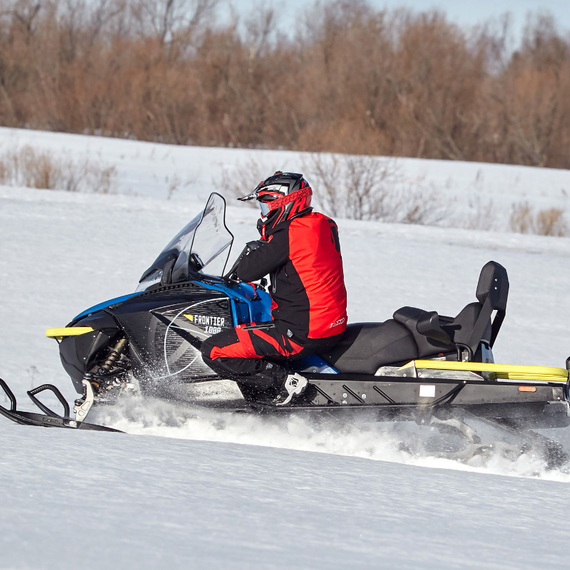Мужчина катится на снегоходе по снежному полю. Фото 15
