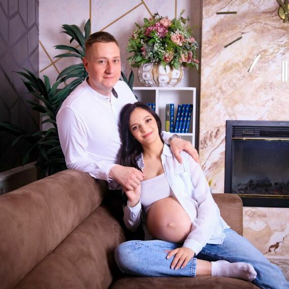 Пара на диване в уютной комнате готовится к появлению ребенка в спокойной обстановке. Фото 6