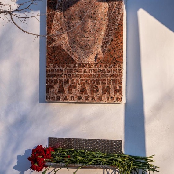 Памятник Юрию Гагарину на стене в городе, окруженном цветами возле мемориала. Фото 30