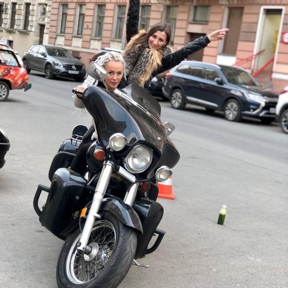 Две девушки на мотоцикле в историческом центре города, вечернее время, атмосфера веселья и приключений. Фото 9