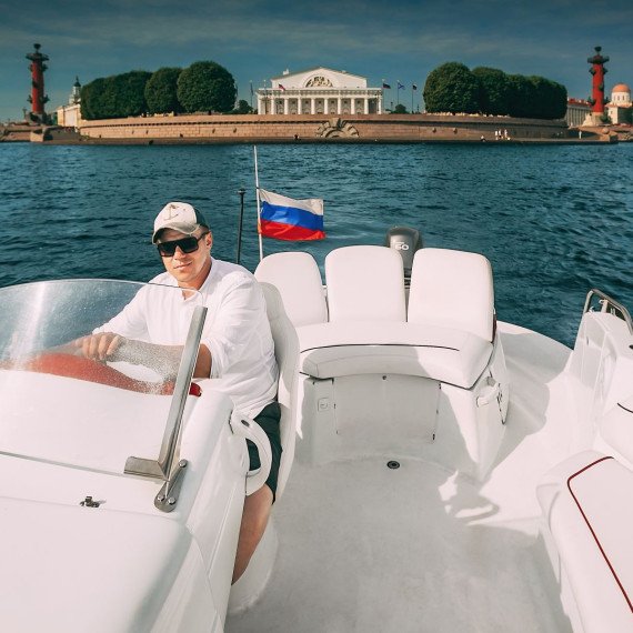 Капитан на лодке в центре Санкт-Петербурга с видом на Эрмитаж и Неву в ясный день. Фото 11