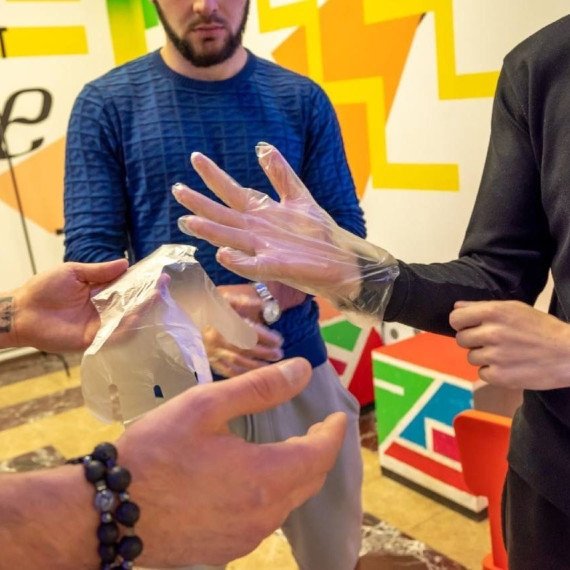 Молодые люди надеты пластиковые перчатки, готовятся к эксперименту в арт-пространстве