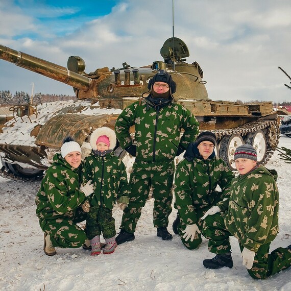 Дети в военной форме позируют с танком на зимнем фоне в лесу. Фото 15