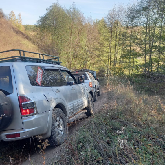 Внедорожные автомобили на лесной дороге в горной местности, окружённой природой и зелеными деревьями. Фото 10