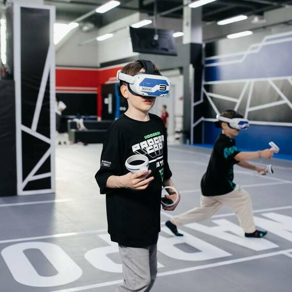 Дети играют в виртуальную реальность в игровом центре с современным оборудованием в 2023 году. Фото 5