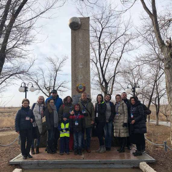 Группа людей у памятника в открытой местности в холодную погоду, ужасные деревья вокруг и хмурое небо. Фото 73