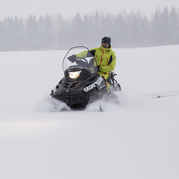 Катание на снегоходе в снежном лесу в зимний день