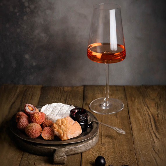 Вино и лакомства на деревянном столе в уютном помещении при мягком свете