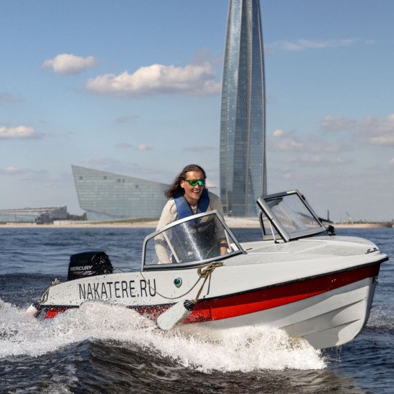 Молодой человек на лодке в водах Санкт-Петербурга с небоскрёбом на фоне. Главное фото