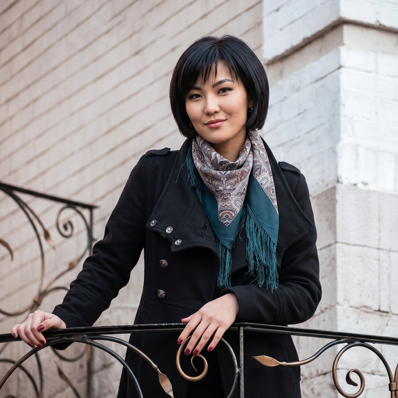 Молодая женщина позирует на балконе в уютном городском районе в осеннее время суток. Главное фото