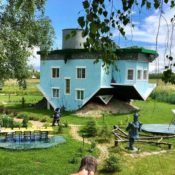 Странный дом с уникальным дизайном в зеленом ландшафте под ярким небом. Фото 10