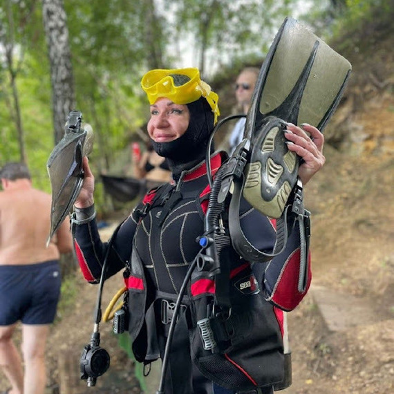 Женщина в снаряжении для подводного плавания с ластами на берегу водоема в теплый летний день. Фото 13