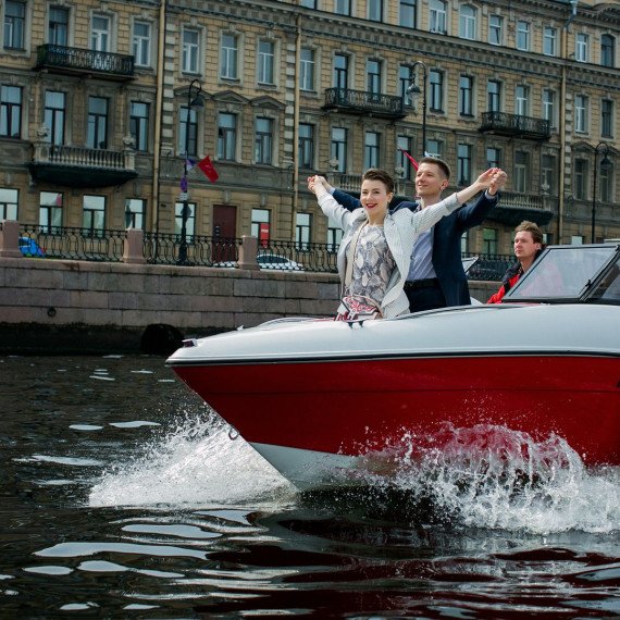 Пара и ребенок радуются на катере в Санкт-Петербурге на реке в солнечную погоду