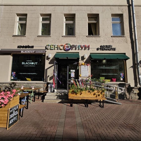 Кафе на улице с террасой и цветами в центре города в солнечный день. Фото 5