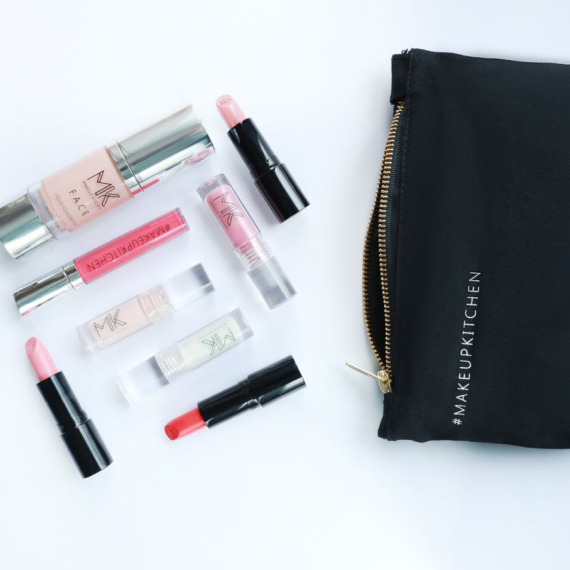 Косметика и сумка находятся на белом фоне с различными средствами для макияжа