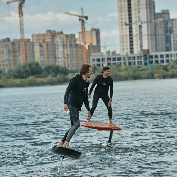 Серфинг на фойле на реке в городе, захватывающее водное развлечение с друзьями в прекрасную погоду. Фото 9