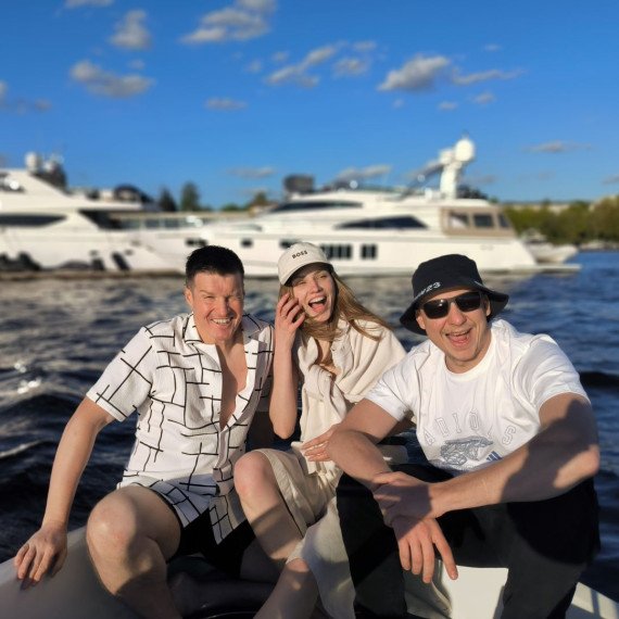 Люди отдыхают на лодке среди яхт в солнечный день