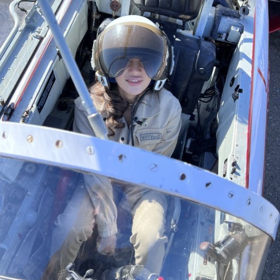 Девушка в кабине самолета, наслаждаясь полетом, в ясный солнечный день