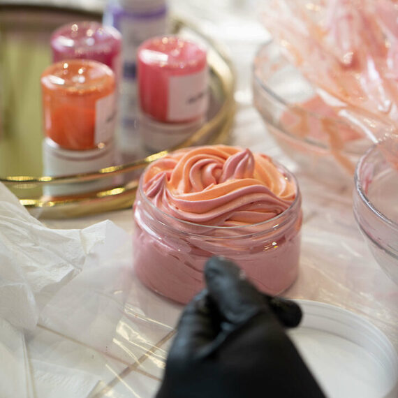 Процесс создания сладостей в кондитерской на столе с розовым кремом