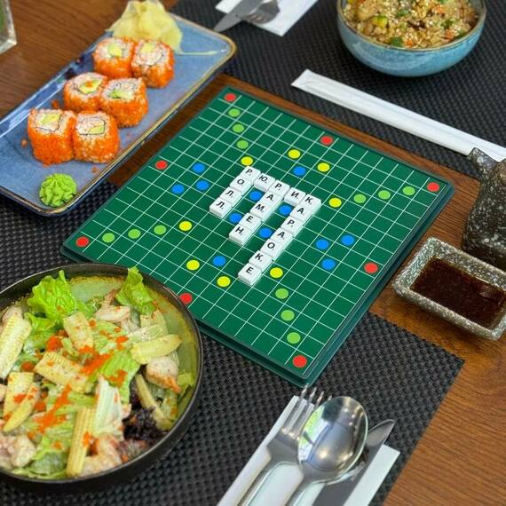 Вкусный ужин с суши и салатами на столе с настольной игрой рядом в уютном ресторане. Фото 10