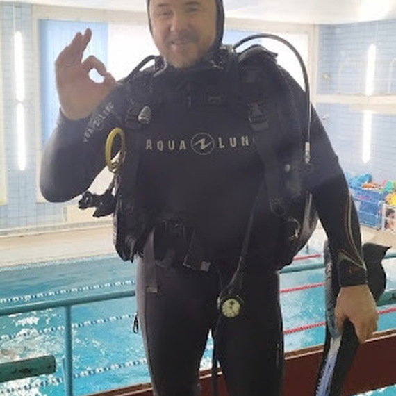 Дайвер в wetsuit на тренировке в бассейне, готовится к погружению и показывает знак ОК. Фото 12