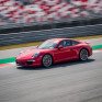 Красный спортивный автомобиль на гоночной трассе во время соревнований на открытом воздухе - превью 1
