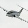 Летящий учебный самолет над облаками, демонстрирующий маневры в ясный день - превью 1