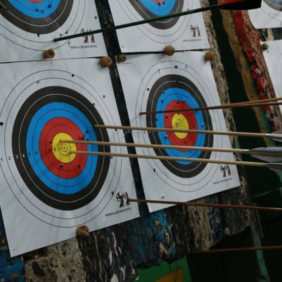 Стрелы попадают в мишени на стрельбище с луком в солнечный день на природе