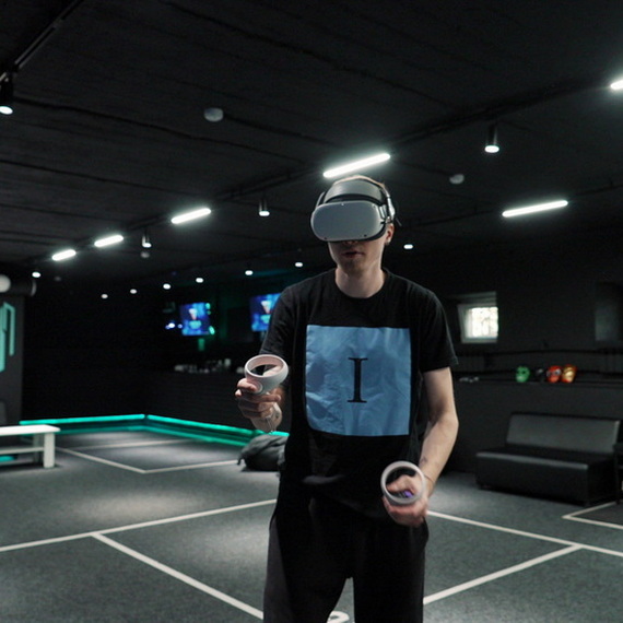 Молодой человек в виртуальной реальности практикует жонглирование в игровом центре в вечернее время. Фото 9