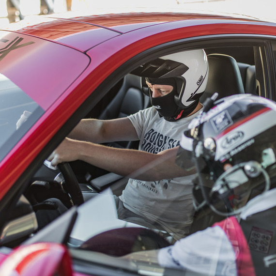 Гонки на спортивных автомобилях на трассе в солнечный день с участниками в защитной экипировке. Фото 8