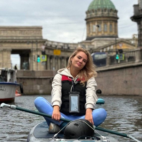 Молодая женщина занимается сап-бордингом на канале в Санкт-Петербурге, наслаждаясь спокойной атмосферой утра. Фото 8