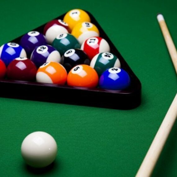 Игра в бильярд с шарами на зеленом сукне и киями в клубе Игра в бильярд с шарами на зеленом сукне и киями в клубе